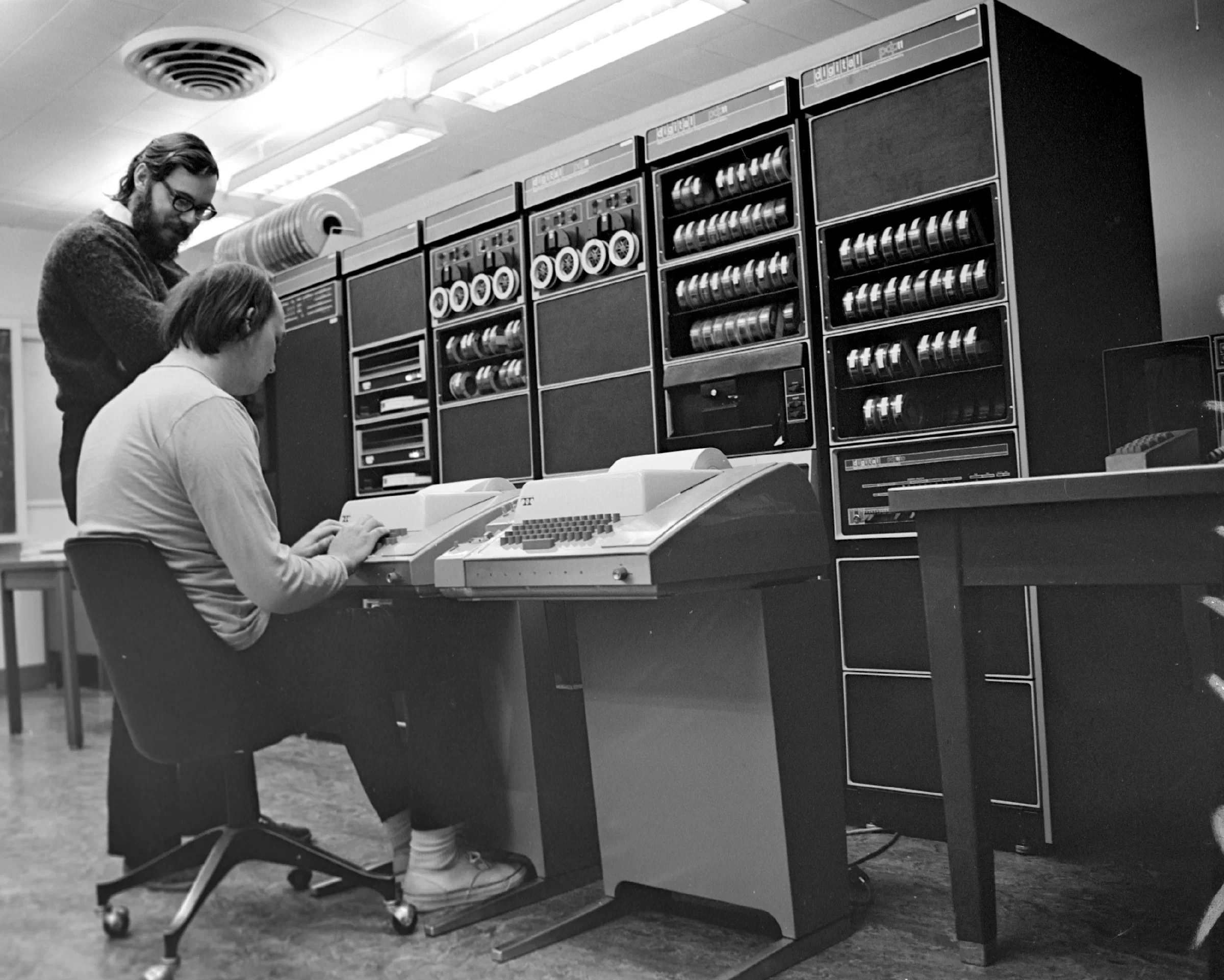 Ken Thompson (坐) 和 Dennis Ritchie (站) 通过电传打字机与 PDP-11 交互。